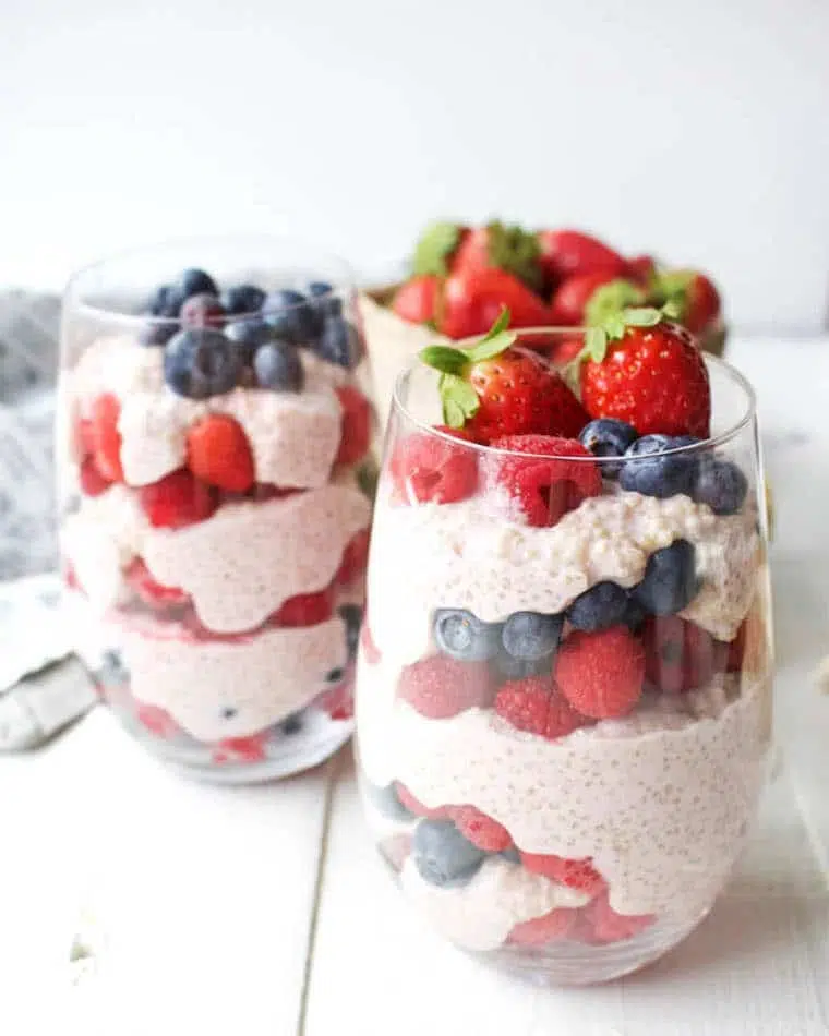 white table with two glasses of homemade vegan berry quinoa parfait