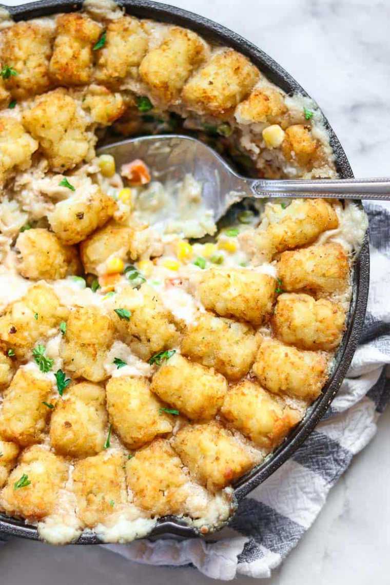 round baking pan with vegan tater tot casserole and a spoon