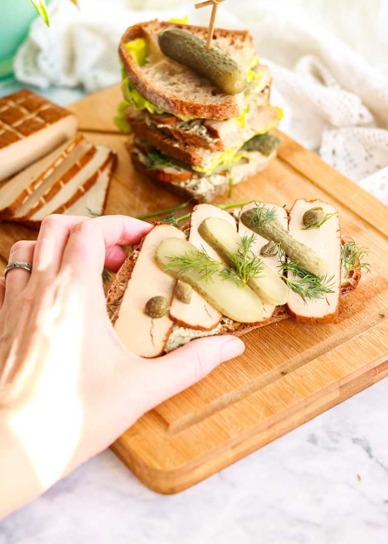 wooden chopping board with several vegan Smoked Tofu Sandwiches
