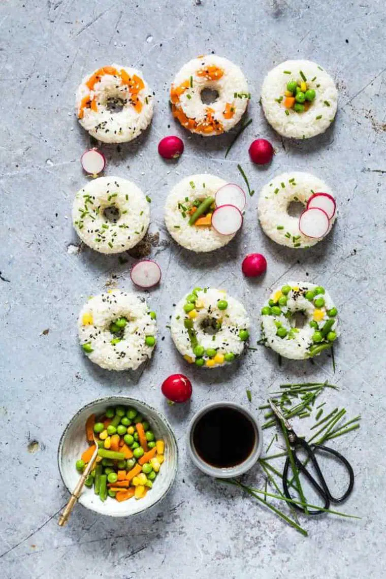 table with 9 rice-based sushi donuts made with different veggies