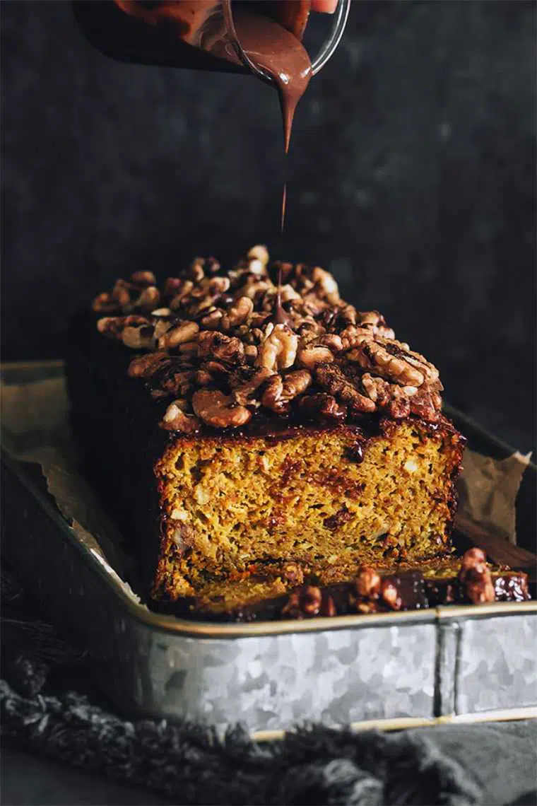 baking pan with vegan pumpkin bread which is drizzled with melted chocolate