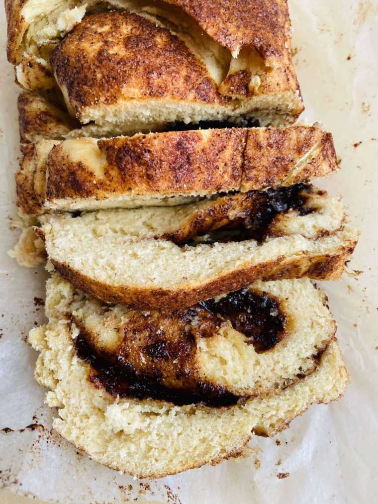 close up of a loaf of vegan cinnamon swirl bread that's been cut into three slices