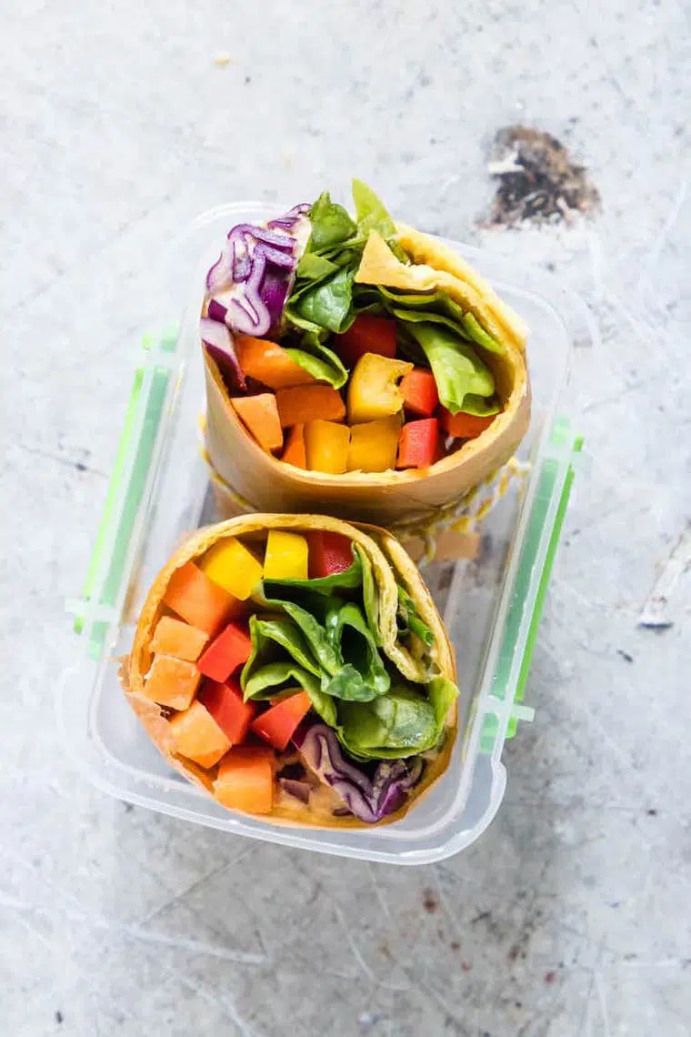 plastic food container with two colorful plant-based vegetable wraps
