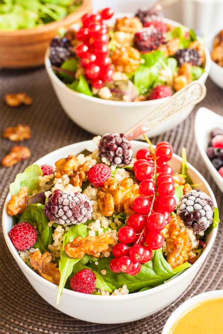 two white bowls with quinoa berry salad and toasted pecans