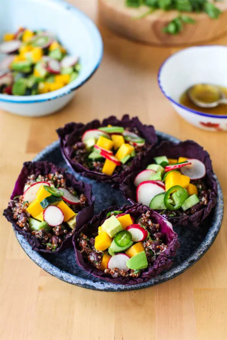 four colorful vegan spring salad cups with avocado