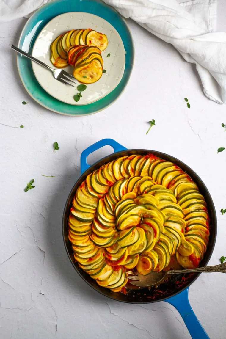 baking dish with colorfully arranged baked zucchini squash and tomato sauce