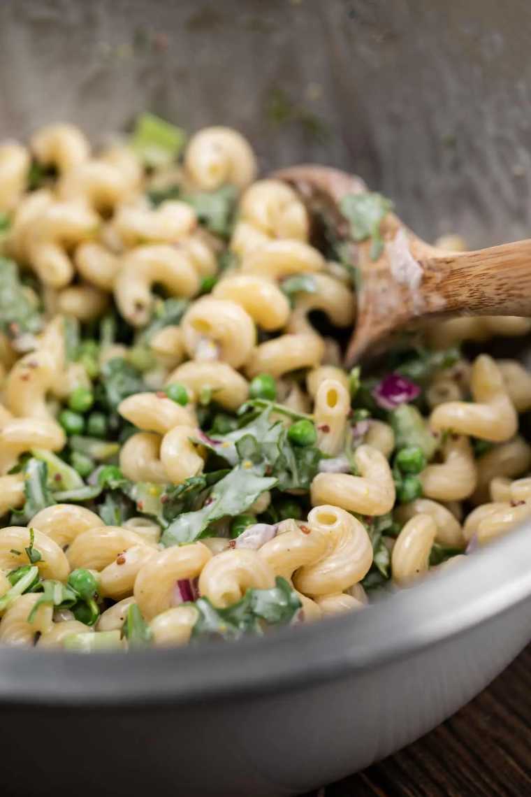 close up of a large bowl filled with Vegan Macaroni Salad and a spoon