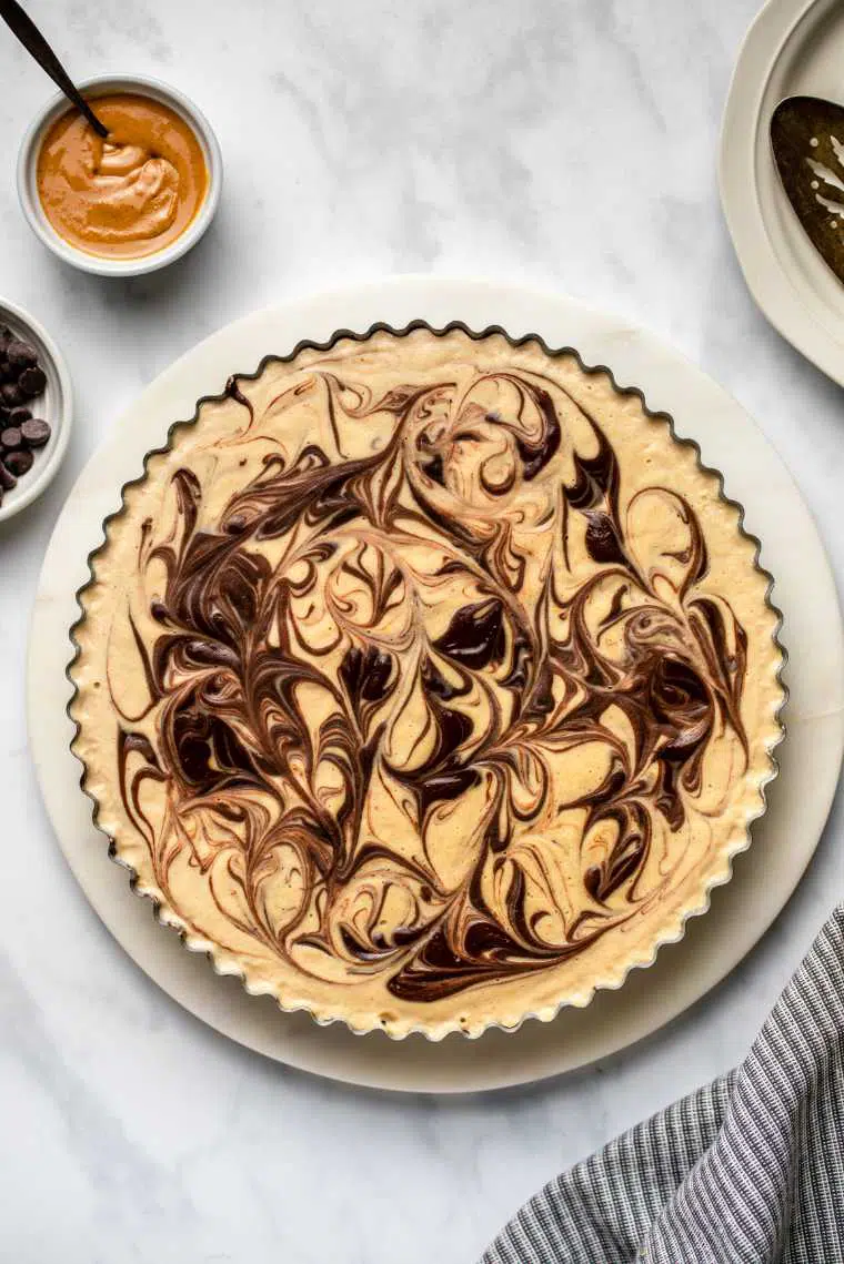 white plate with a homemade no-bake peanut butter pie with chocolate swirls