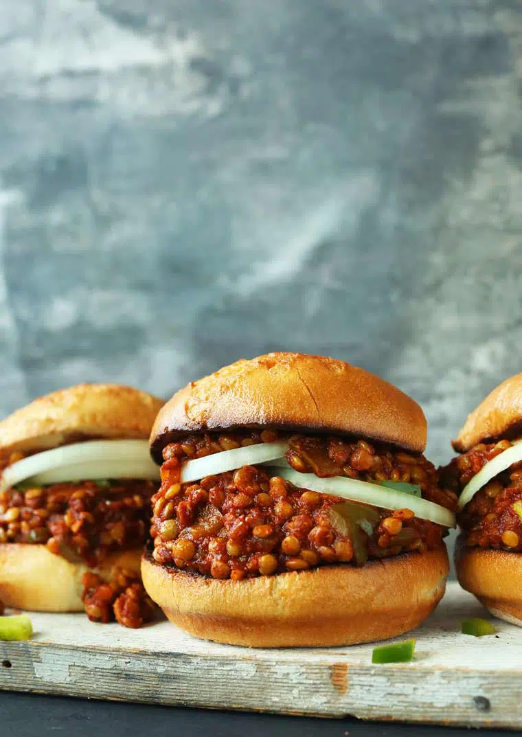 wooden board with three homemade vegan sloppy joes next to each other
