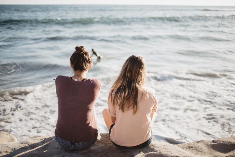 women sitting at the beach