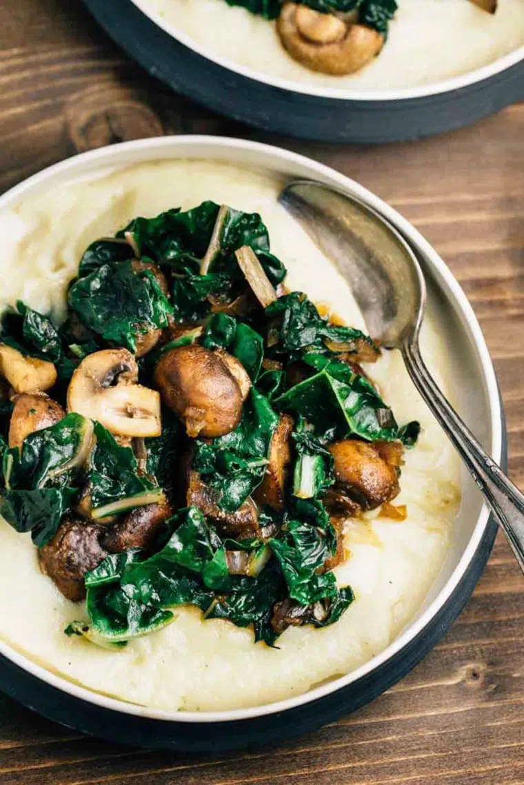 two bowls of mashed cauliflower with oil-free sauteed mushrooms and greens