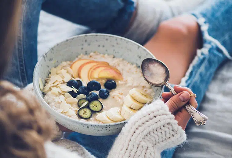woman eating oatmeal with fruit