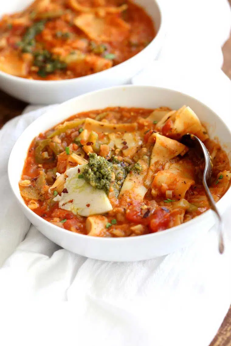 two white bowls with homemade Vegan Instant Pot Lasagna Soup and a spoon