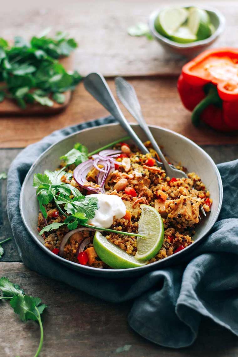 wooden table with bell pepper, herbs and a bowl of cooked quinoa veggie biryani