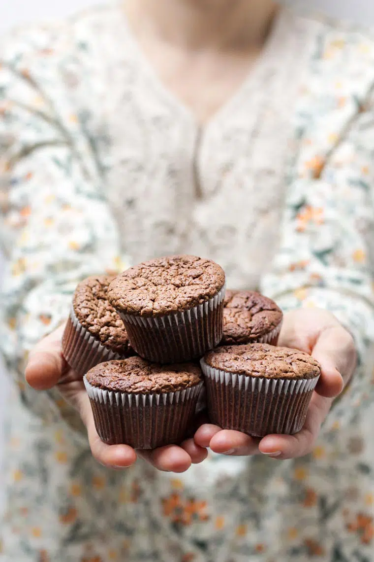 woman holding chocolate cupcakes in her hands