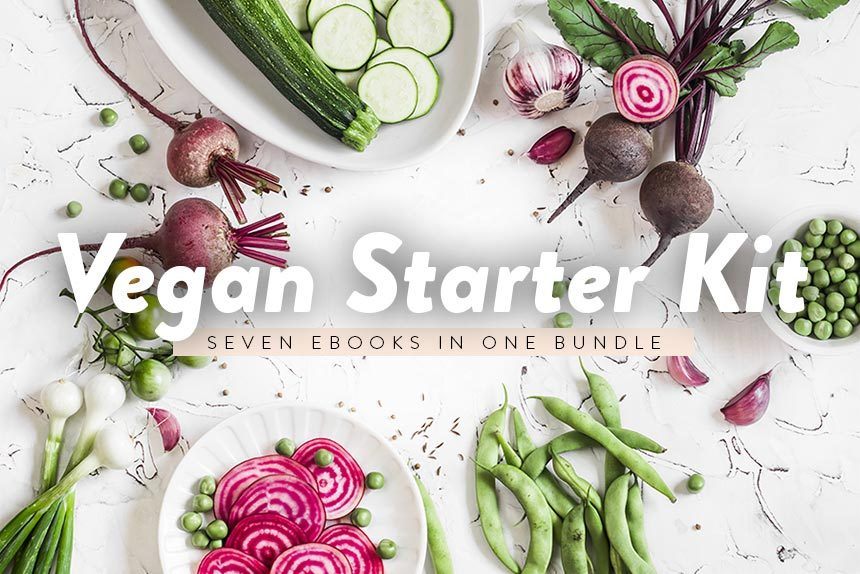 Vegan Starter Kit written over different green and purple vegetables lying on a white table