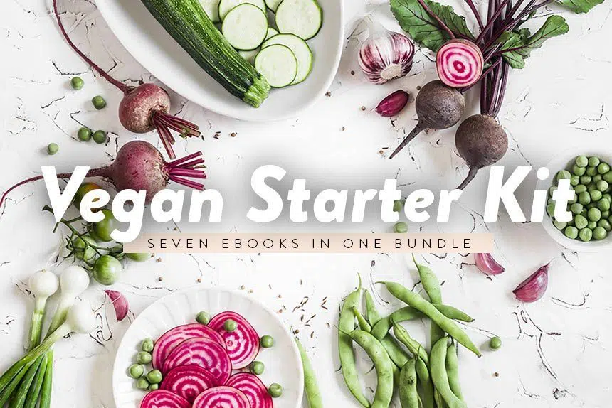 Vegan Starter Kit written over different green and purple vegetables lying on a white table