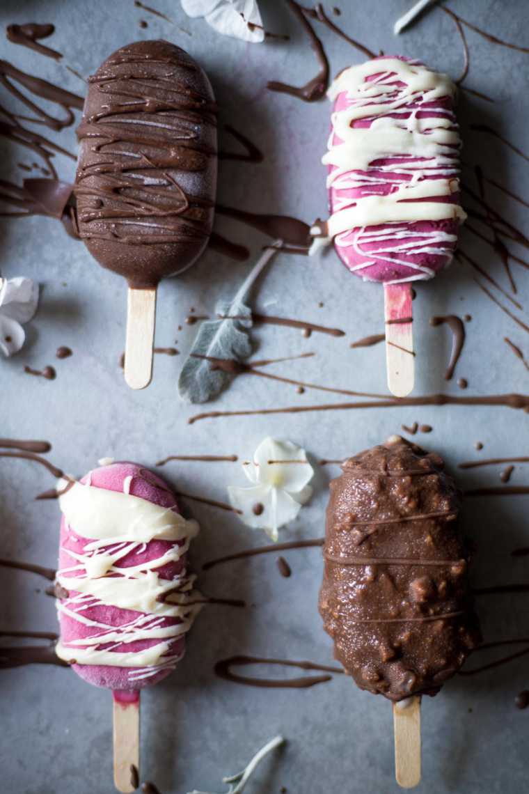 table with two pink and two brown vegan magnum ice cream with drizzle