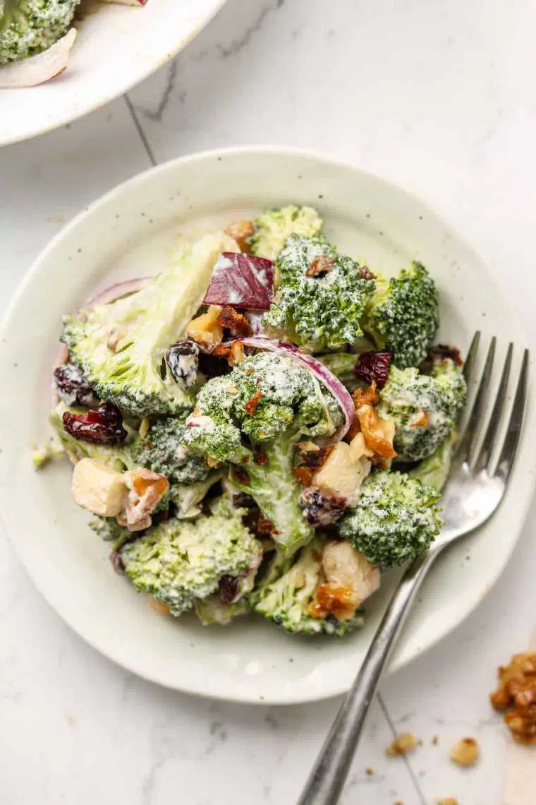 white plate with crunchy vegan broccoli salad and a creamy dressing