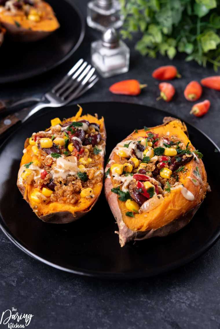 black plate with two Mexican Quinoa Stuffed Sweet Potatoes for a light vegan dinner