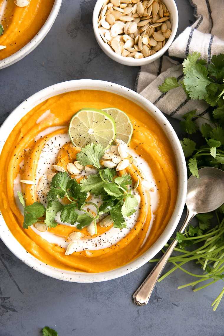 two white bowls filled with creamy Curried Pumpkin Soup