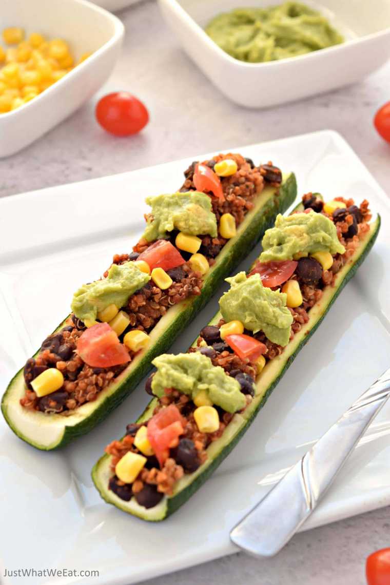white plate with two vegan Mexican Zucchini Boats and avocado