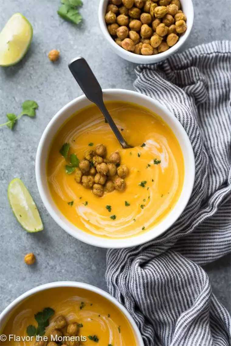 table with two bowls of Instant pot carrot ginger soup with crispy chickpeas