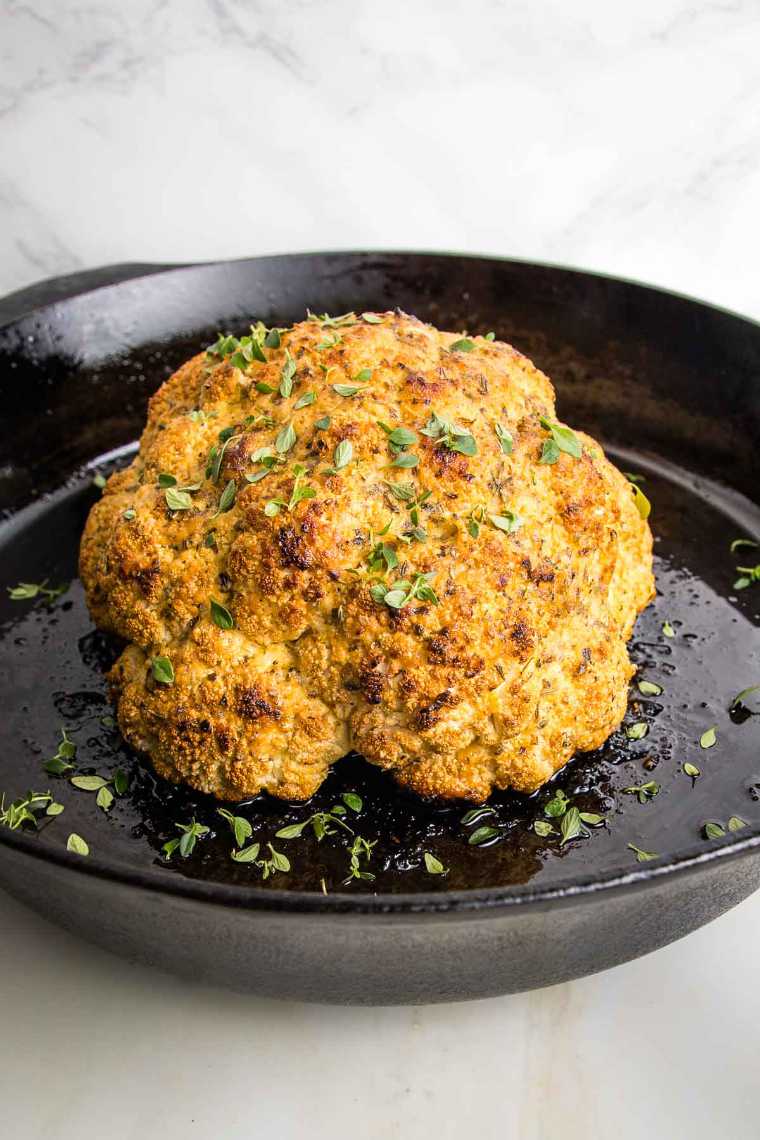 black pan with a golden brown Whole Roasted Cauliflower