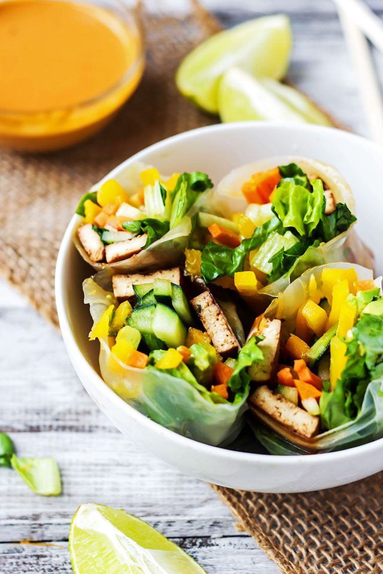 white bowl with several rice paper wrapped teriyaki tofu and raw veggie wraps