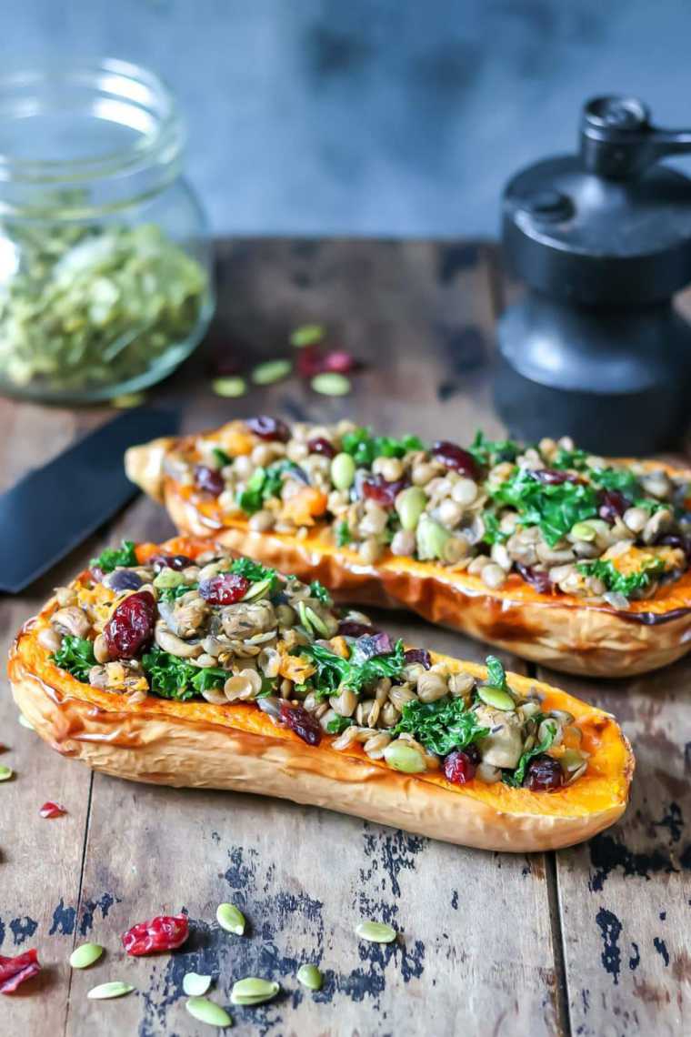 wooden table with two colorfully stuffed butternut squash halves