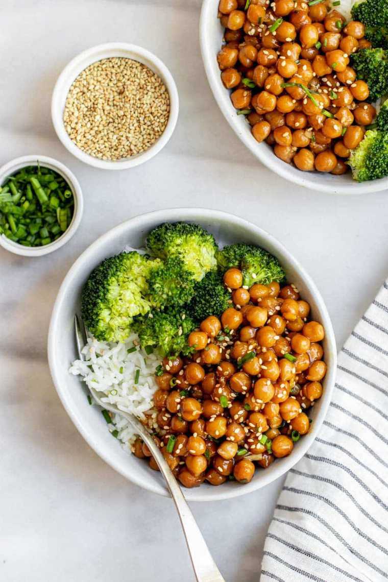 two white bowls with white rice, steamed broccoli and sesame chickpeas