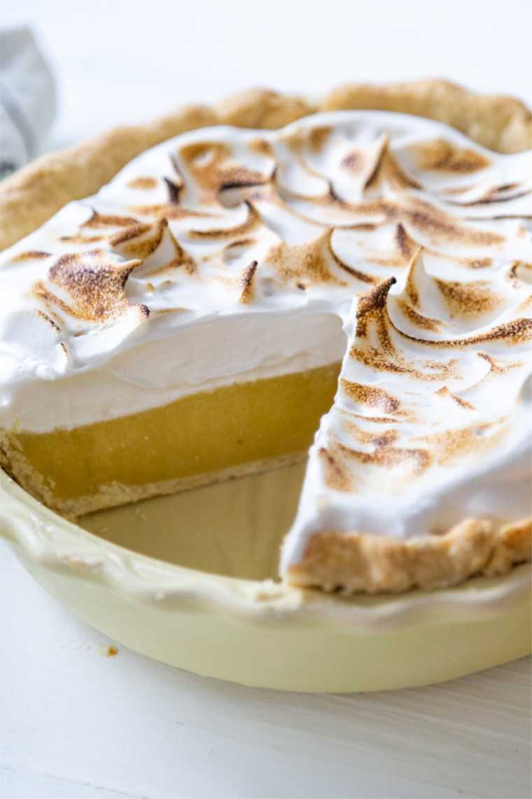 close up of a baking dish with Vegan Lemon meringue Pie where one slice has been cut out