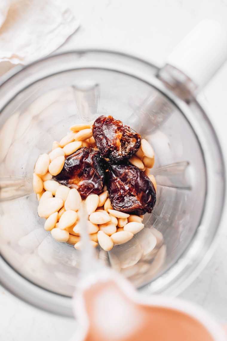 top view of a blender jar filled with almonds, dates and water