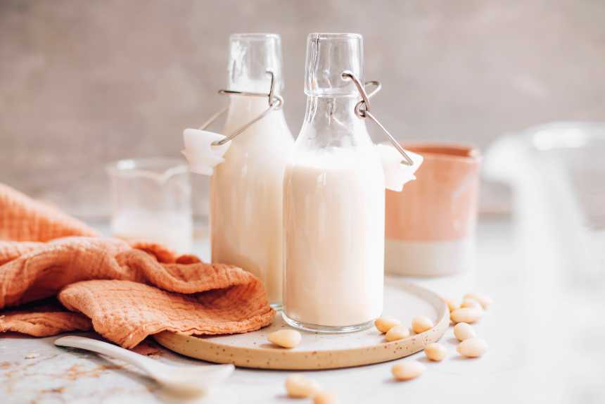 white table with a towel and two bottles of vegan almond creamer