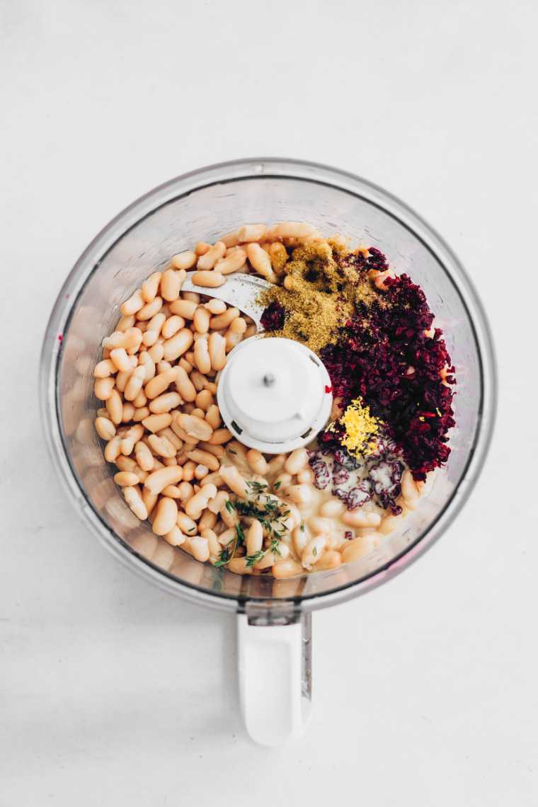 food processor with white beans, spices and other ingredients for a beetroot dip