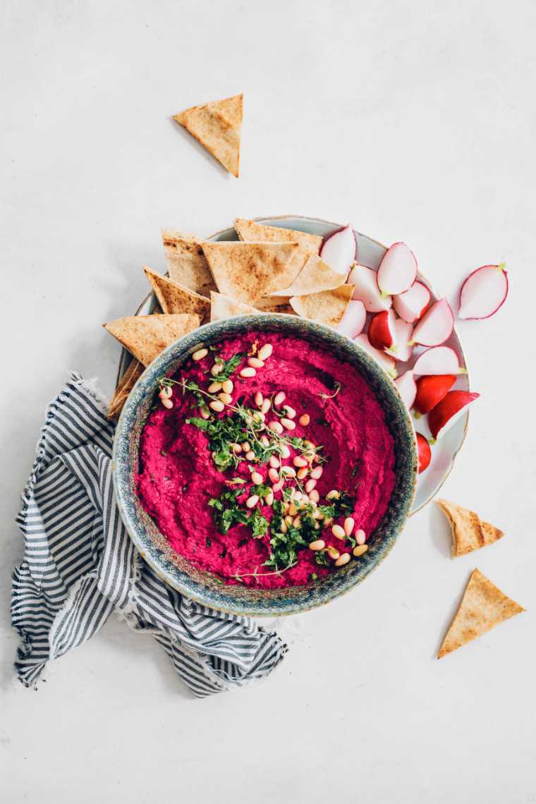 plate with radishes, chips and a bowl of roast beet hummus