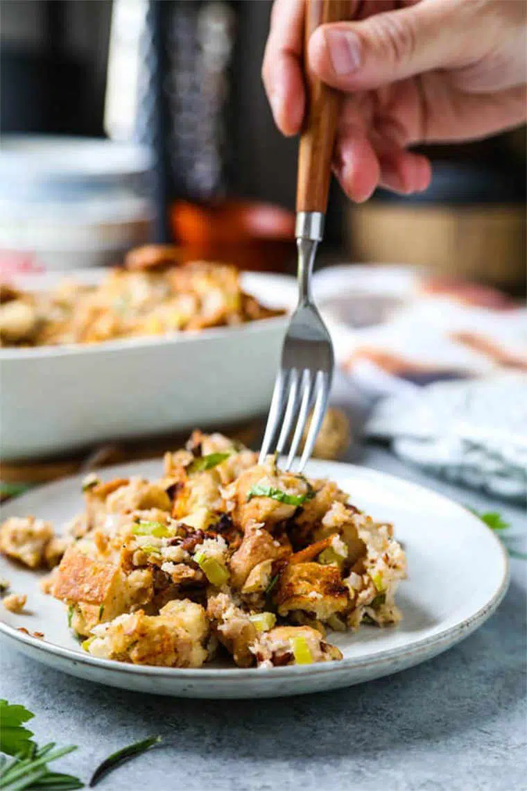 white plate with healthy vegan christmas stuffing being picked up by a fork