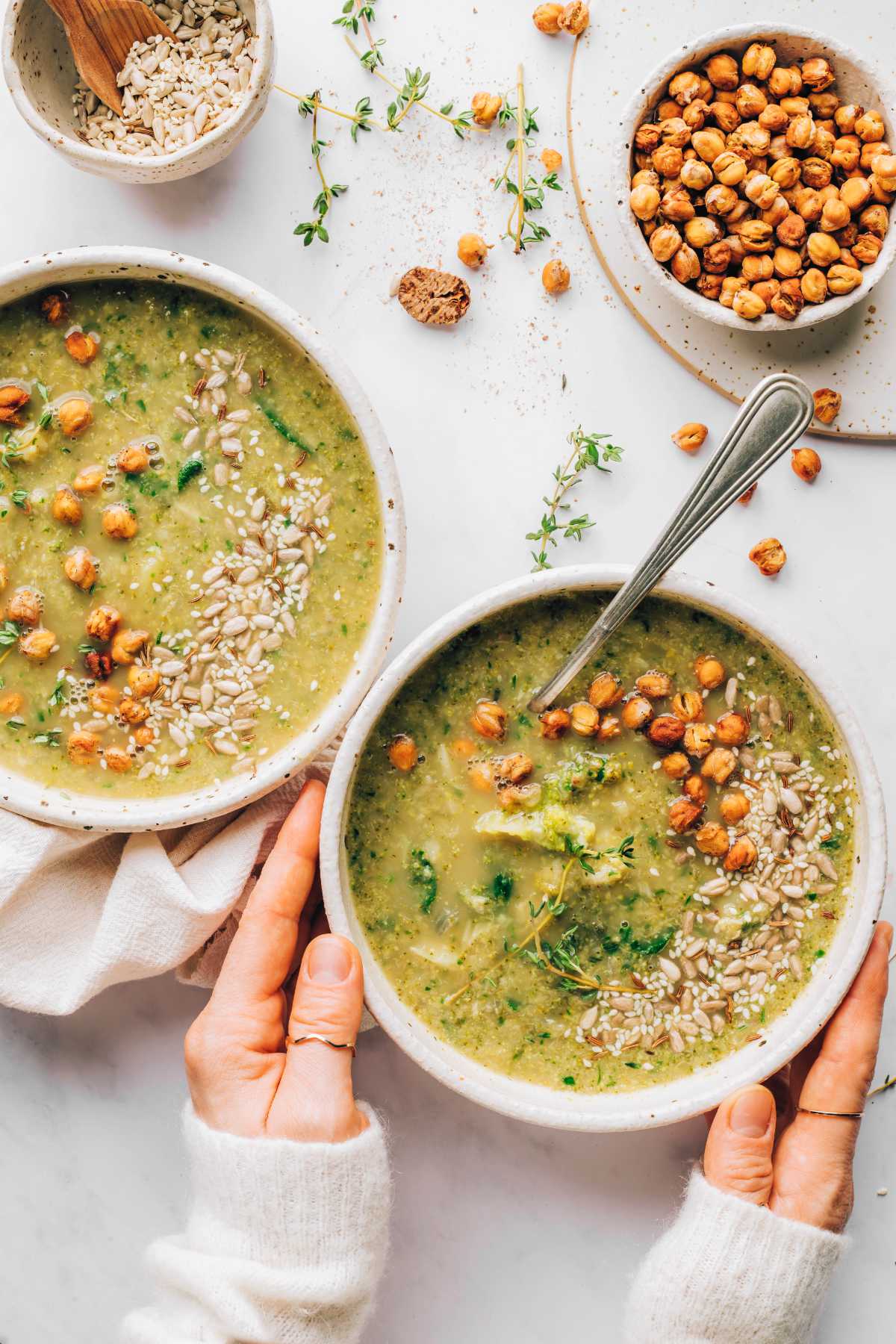 two bowls of vegan broccoli soup on a table