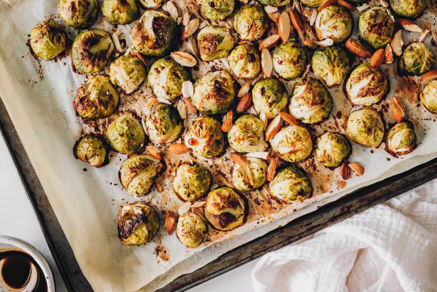 baking sheet with roasted vegan Teriyaki Brussels sprouts and almonds
