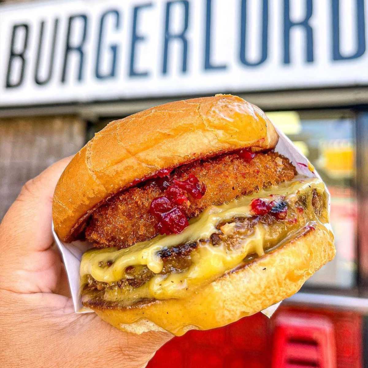 hand holding a rich vegan burger