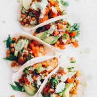 five vegan buffalo cauliflower tacos on a white plate
