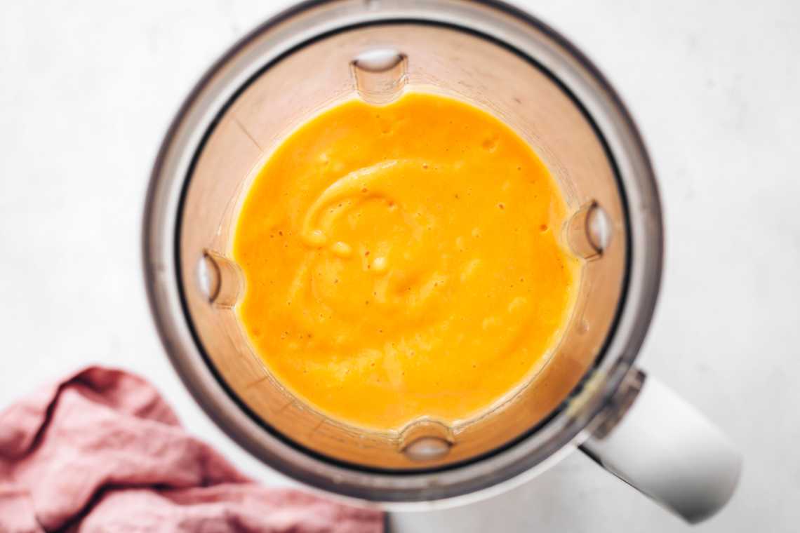 Creamy mango smoothie little liquid in a blender