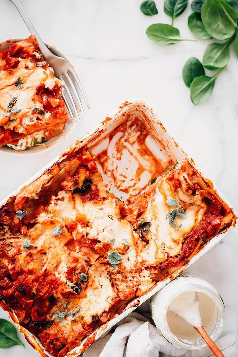 baking dish with creamy dairy free vegan lasagna where a piece has been cut out