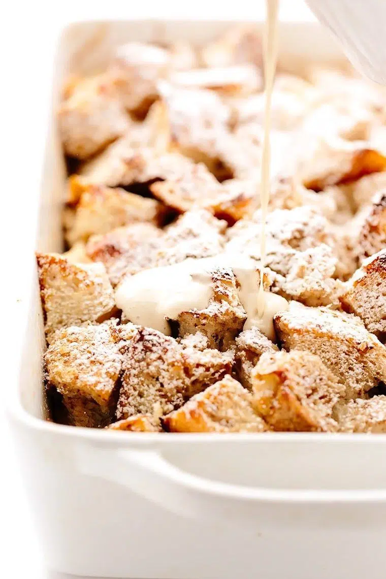 white baking dish with cut up french bread and thick white vegan sauce