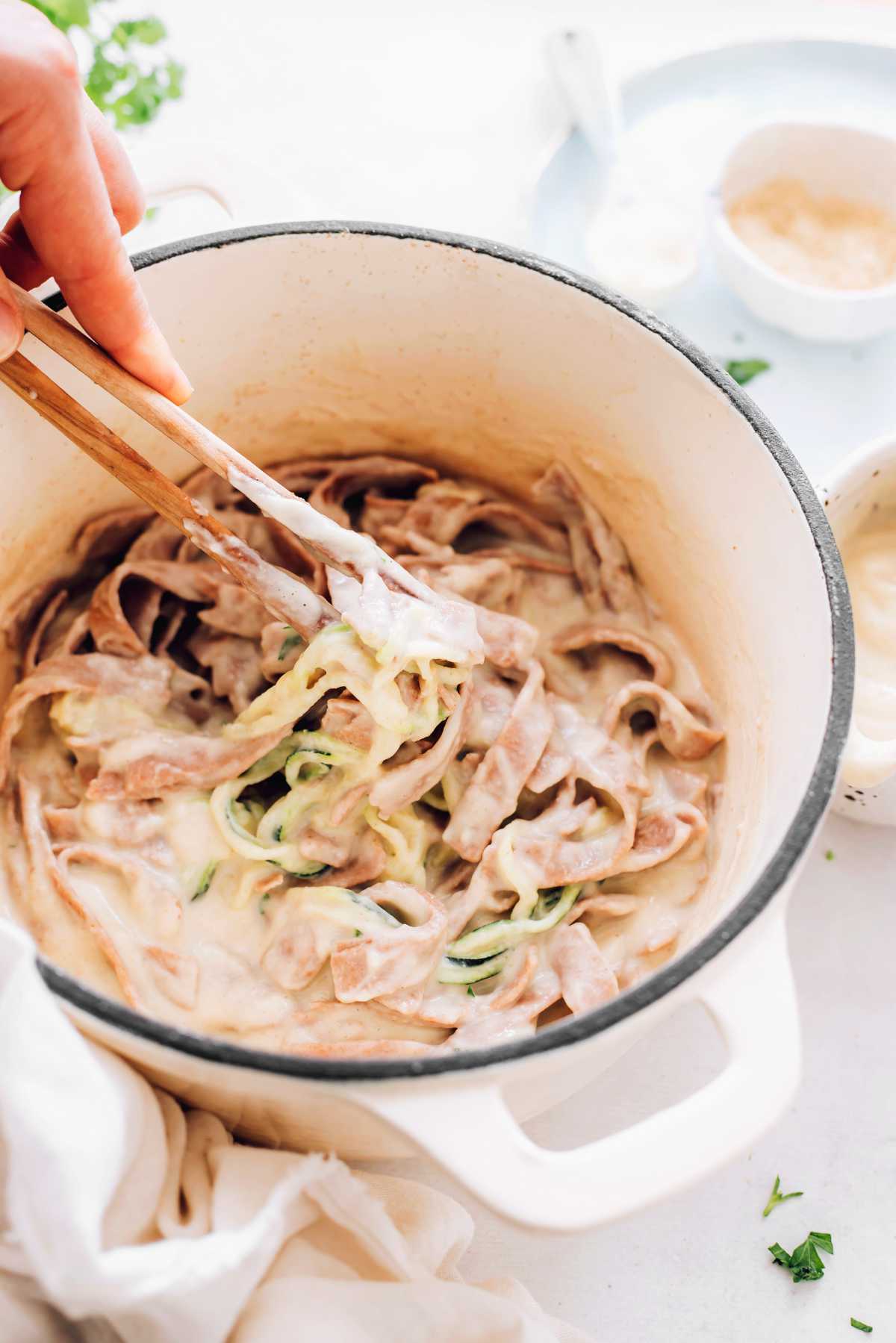 homemade Fettuccine Alfredo on wooden tongs