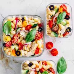 glass containers with colorful vegan pasta salad on a table
