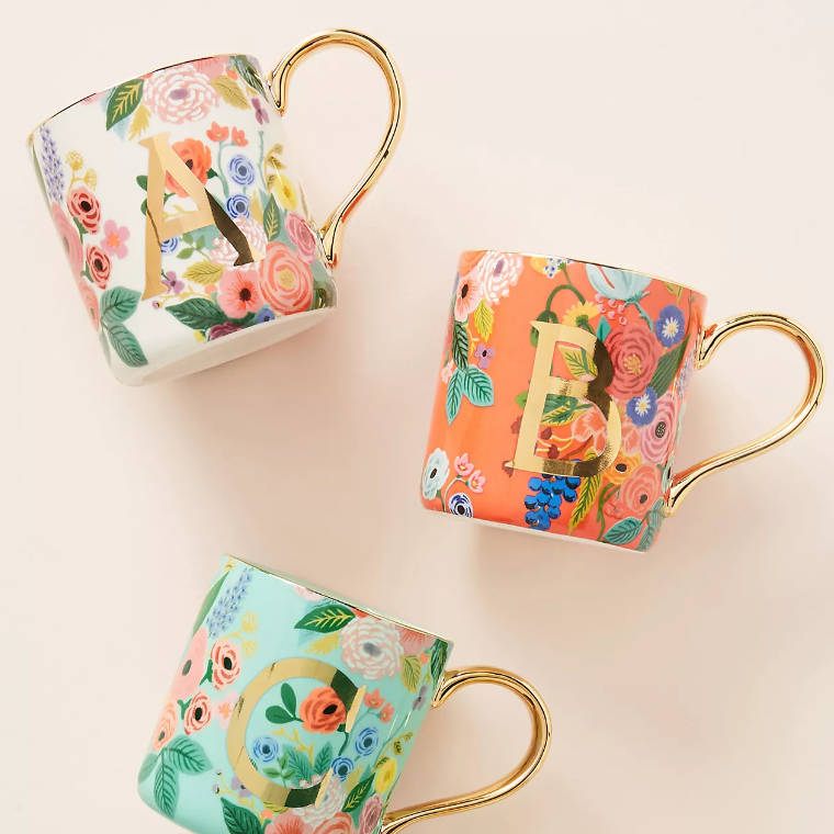 three different colored mugs with floral print, golden handles and a monogram letter