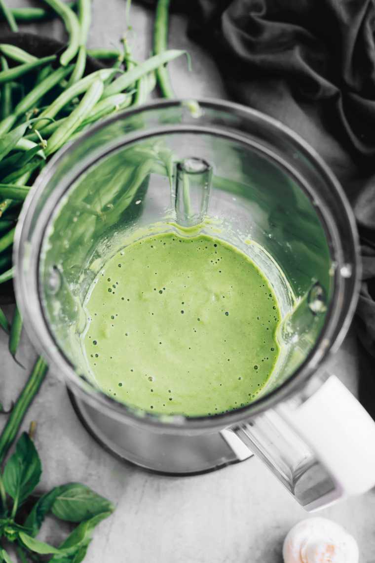 top view of a blender jar with homemade green oil-free pesto