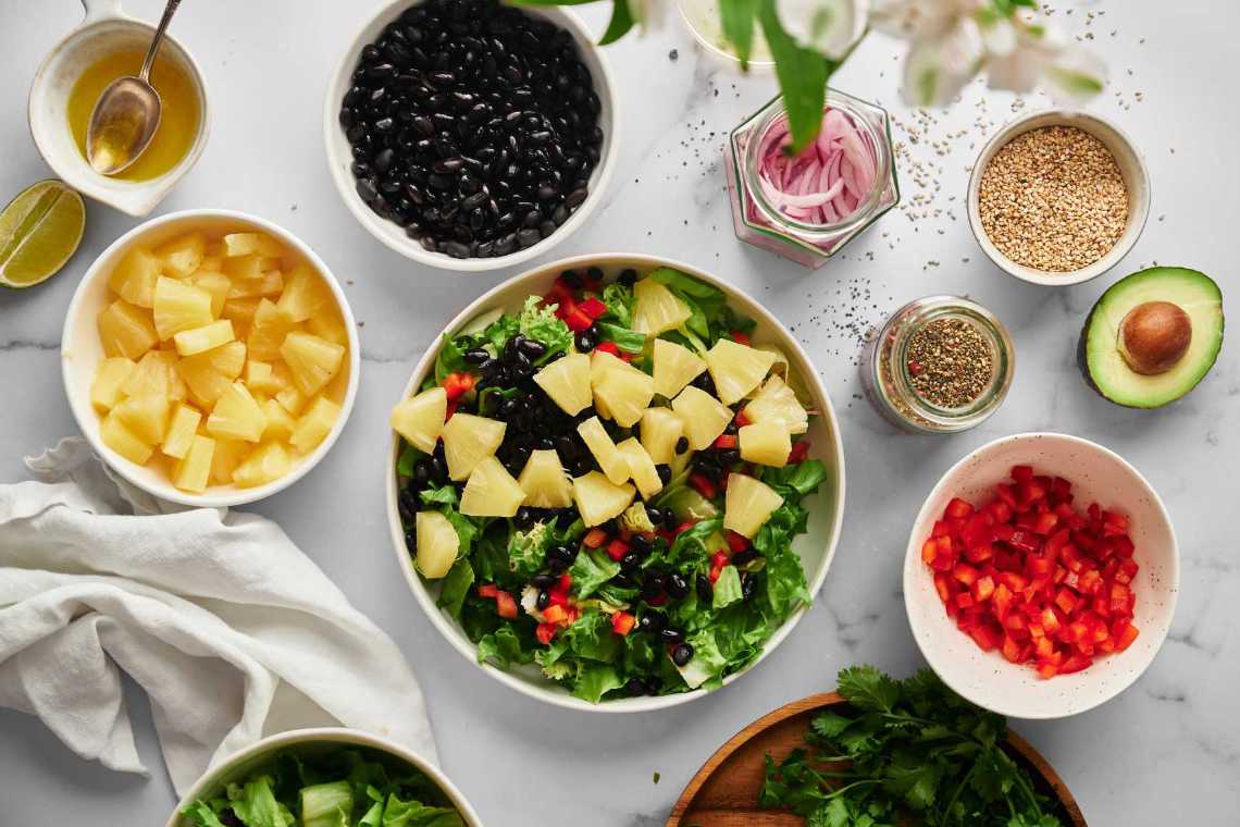 table with different vegetables and ingredients for a salad