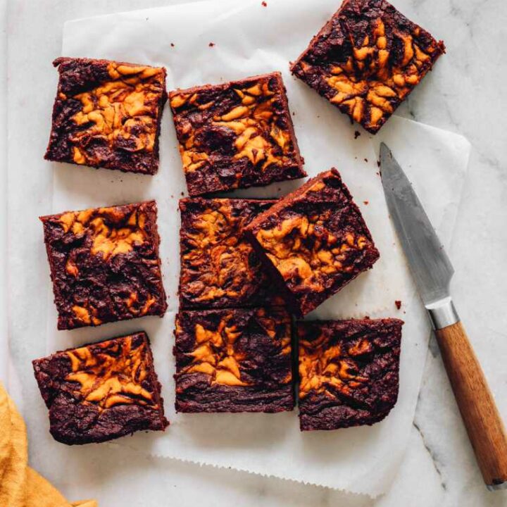 cutting board with 9 freshly baked pumpkin brownies and a knife